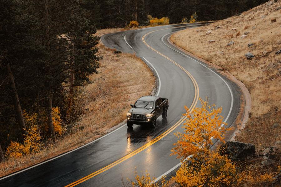 Car on a winding mountain road in autumn fog
