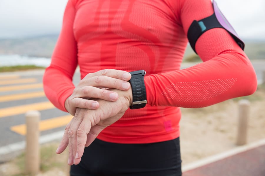 A runner checking the GPS watch on their wrist
